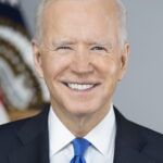 Official portrait of President Joe Biden, smiling in a suit and tie, representing his leadership as the 46th President of the United States