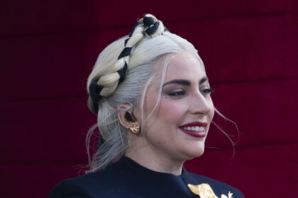 Lady Gaga at Joe Biden's inauguration in a navy outfit, singing on stage with a golden microphone