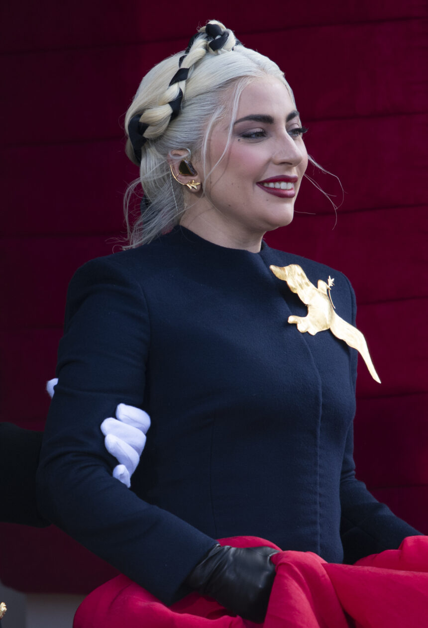 Lady Gaga at Joe Biden's inauguration in a navy outfit, singing on stage with a golden microphone