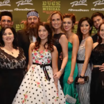 The cast of Duck Dynasty poses for a group photo at an event, showcasing their iconic styles and smiles.