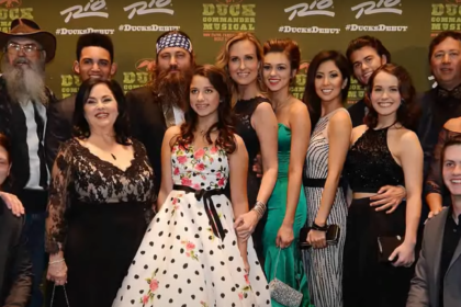 The cast of Duck Dynasty poses for a group photo at an event, showcasing their iconic styles and smiles.