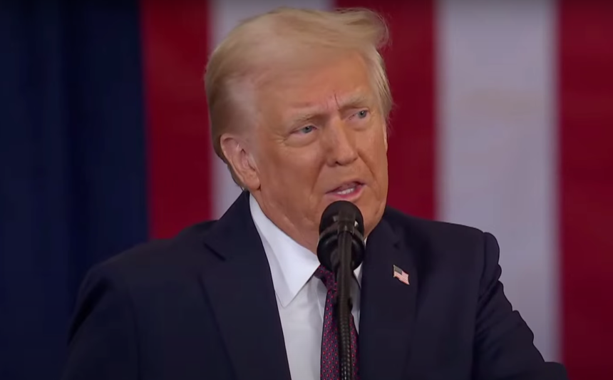 Donald Trump speaking at a public event, addressing an audience with a serious expression.