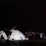 Potomac River plane crash wreckage at night with emergency rescue efforts underway.