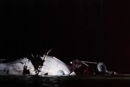 Potomac River plane crash wreckage at night with emergency rescue efforts underway.