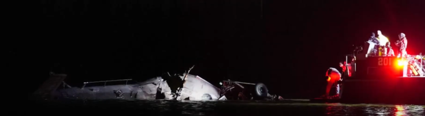 Potomac River plane crash wreckage at night with emergency rescue efforts underway.