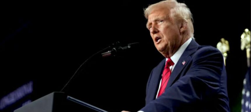 Donald Trump speaking at a public event, addressing policies related to federal funding and Medicaid. The image highlights his role in shaping government decisions affecting healthcare, grants, and social services.