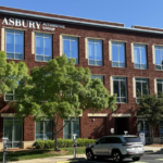 Asbury Automotive Group headquarters building with green trees in front.