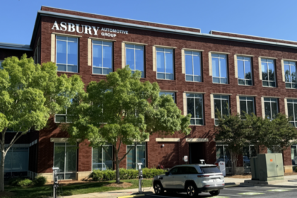 Asbury Automotive Group headquarters building with green trees in front.