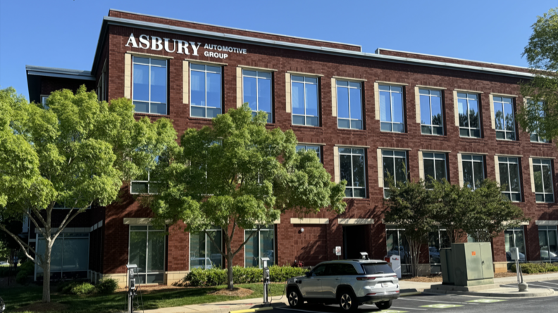 Asbury Automotive Group headquarters building with green trees in front.