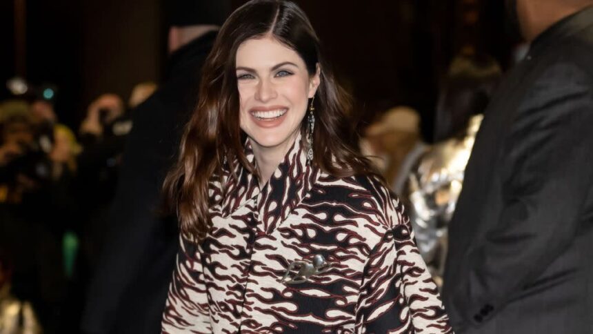 Alexandra Daddario at a public event, smiling and posing for the cameras.