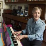 Paul McCartney playing the piano at home, showcasing his musical talent and timeless passion for music.