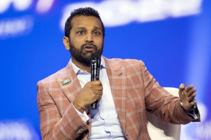 Kash Patel wearing a suit, raising his right hand as he takes the oath to become FBI Director.