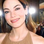 Michelle Monaghan attending a red carpet event, smiling in a beige dress with elegant makeup.