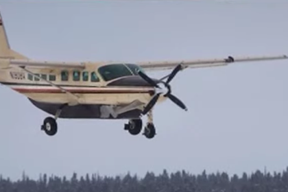 Small aircraft taking off from a remote Alaskan airstrip, symbolizing aviation in rugged terrain.