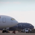 Airplane on the runway with a background of sky and other aircraft.