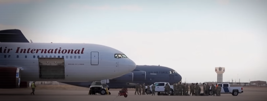 Airplane on the runway with a background of sky and other aircraft.