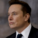 Elon Musk looking serious in a formal setting.