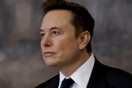 Elon Musk looking serious in a formal setting.