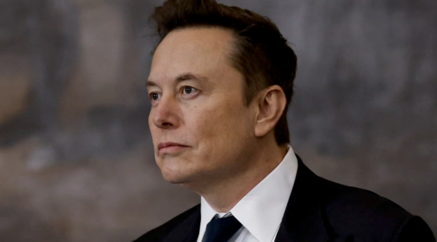 Elon Musk looking serious in a formal setting.