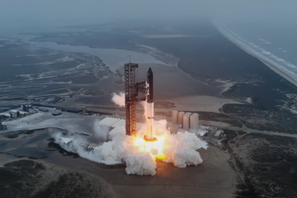 SpaceX rocket launch captured mid-flight, leaving a bright trail of smoke and fire as it ascends from the launch pad into the sky.