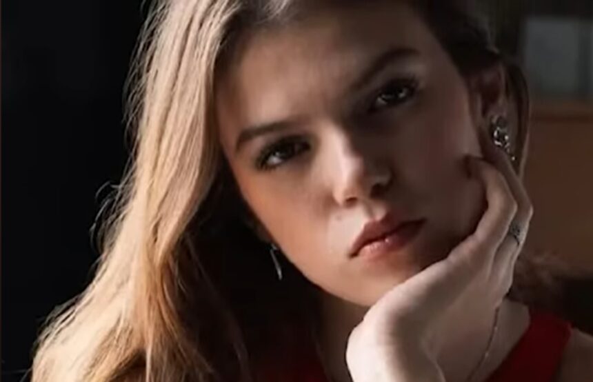 Close-up portrait of a young woman with a thoughtful expression, looking slightly away from the camera.