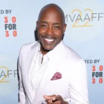 Will Packer at a public event, smiling in a white suit.