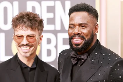 Colman Domingo smiling and posing in a stylish suit at an awards event