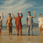 Cast of The White Lotus Season 3 standing on a beach in Thailand, set against a dramatic sunset, representing the show’s new exotic and mysterious setting.