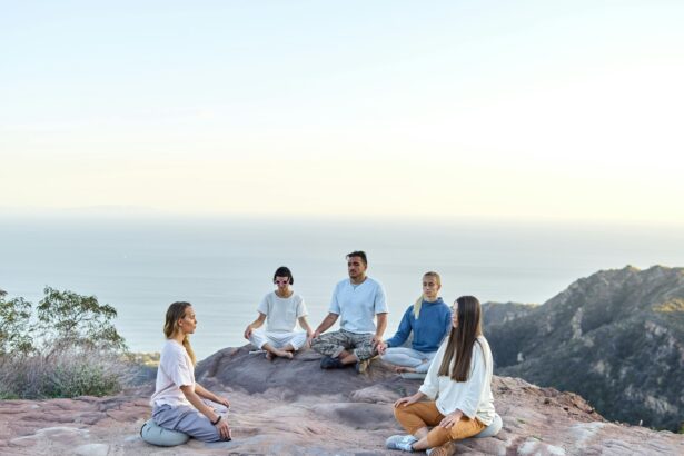 A group of people meditating together on a scenic hilltop during sunrise, embracing mindfulness and holistic wellness.