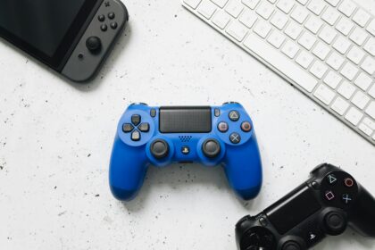 PlayStation 5 controller on a white desk with gaming accessories.